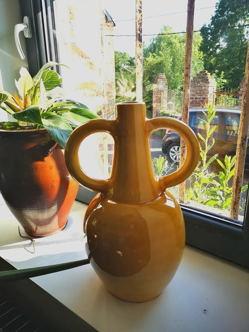 Vase jaune devant fenetre